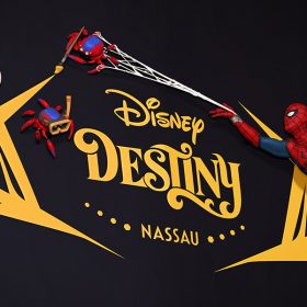 An artist rendering of the Disney Destiny stern depicts Spider-Man webbing up a Spider-Bot that is holding a paintbrush. Next to it are two additional Spider-Bots—one holding a striped innertube and a set of goggles and another wearing a scuba diving mask.