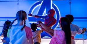 At Marvel Super Hero Academy in Disney’s Oceaneer Club, Spider-Man demonstrates how to shoot webs from his wrists as five children gather around the stage.