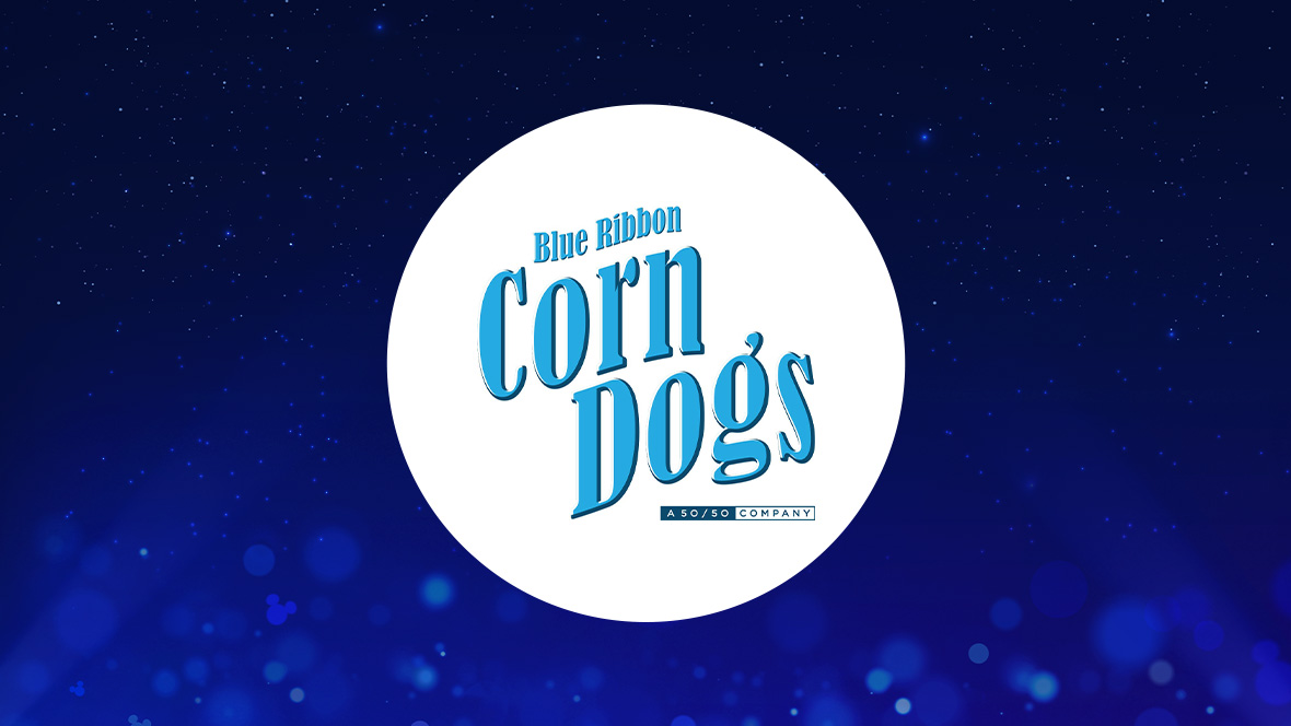 The image features a white circle centered against a deep blue background with small light effects and sparkling points, creating a magical atmosphere. Inside the circle, the text "Blue Ribbon Corn Dogs" is written in a stylized blue font. Below this text, in smaller blue letters, it reads "A 50/50 COMPANY."