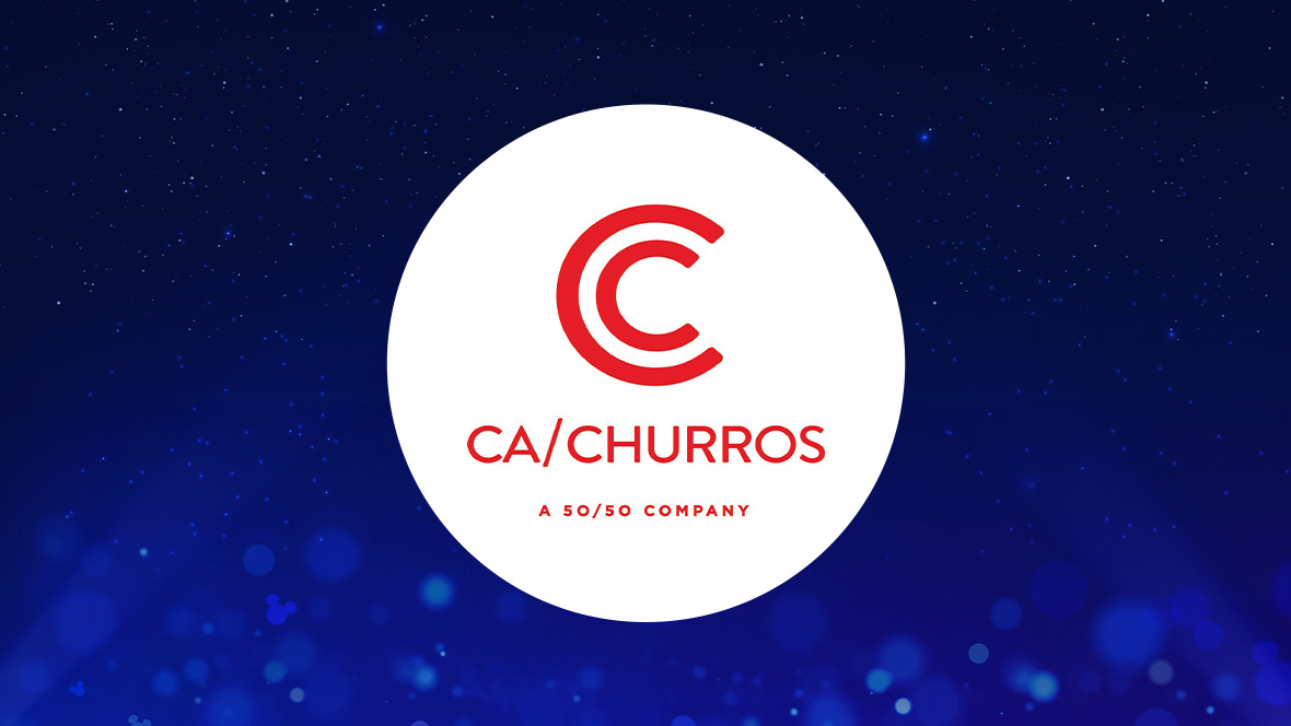 The image shows a white circle in the center with a red stylized "C" logo at the top, followed by the text "CA/CHURROS" in red capital letters. Below this text, in smaller red letters, it reads "A 50/50 COMPANY." The background is a deep blue with subtle light effects and small sparkling points of light, creating a magical and enchanting atmosphere.