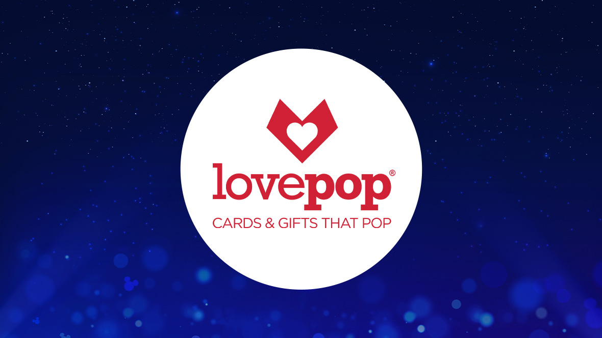 The image features a white circle centered on a dark blue background with subtle sparkling light effects. Inside the circle, the word "lovepop" is written in bold red lowercase letters. Above the text, there is a red heart icon. Below "lovepop," the tagline "CARDS & GIFTS THAT POP" is written in smaller red uppercase letters.