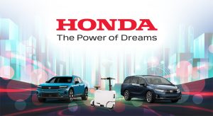 Graphic with a white and light blue background, featuring the Honda logo and the slogan 'The Power of Dreams' at the top. Below the text, there are images of two Honda vehicles and a scooter, with a futuristic cityscape in the background."