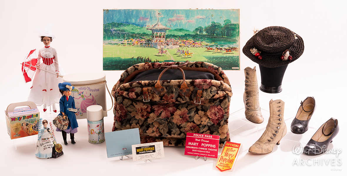 A collection of Mary Poppins paraphernalia arranged around Mary’s carpet bag, at the center, includes Poppins dolls and pins, a ticket from the premiere, a hat and two pairs of shoes worn by star Julie Andrews, and more.