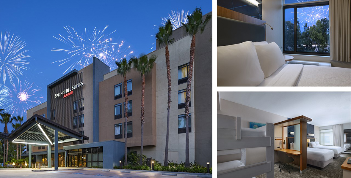 Exterior view of the SpringHill Suites by Marriott with fireworks lighting up the sky in the background. The hotel has a modern design with tall palm trees in front. On the right, two smaller images show the interior of the hotel rooms. One room features a comfortable bed with a window view of the fireworks, while the other room has bunk beds and a desk area, with another bed visible in the background.