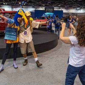 Guests are seen posing in front of Walt Disney’s Mercedes Benz on the show floor at “A Great Big Beautiful Car Show,” during D23: The Ultimate Disney Fan Event.