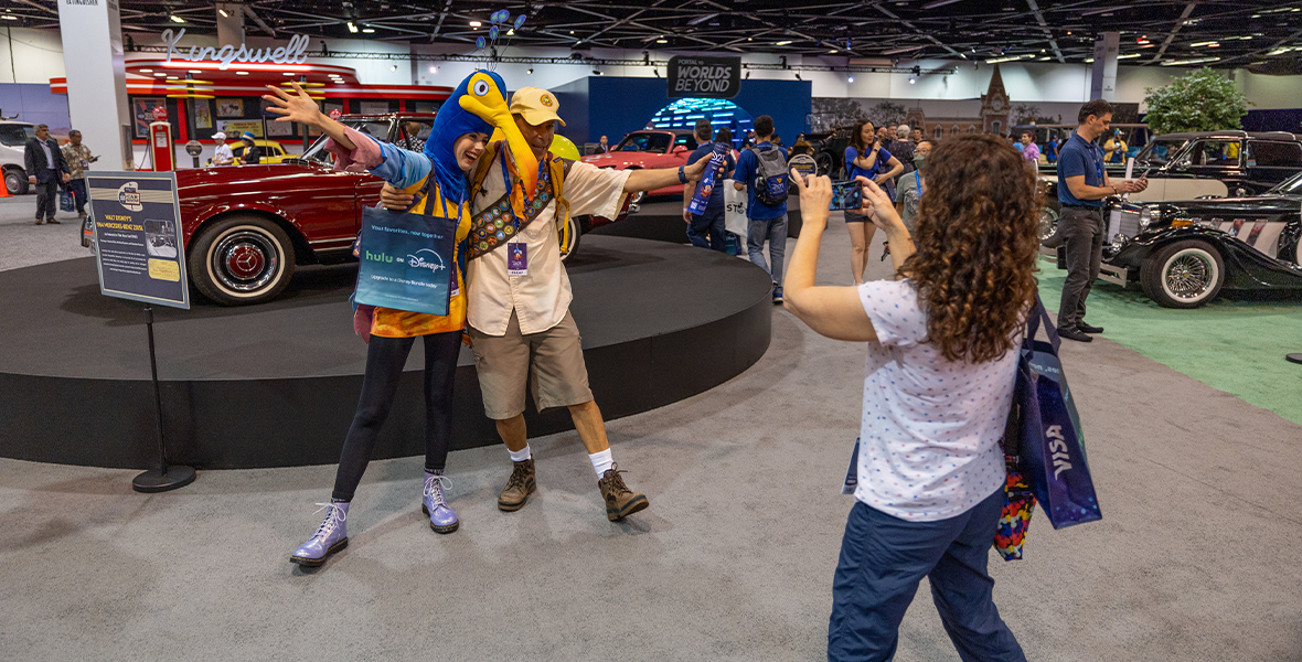 Guests are seen posing in front of Walt Disney’s Mercedes Benz on the show floor at “A Great Big Beautiful Car Show,” during D23: The Ultimate Disney Fan Event.