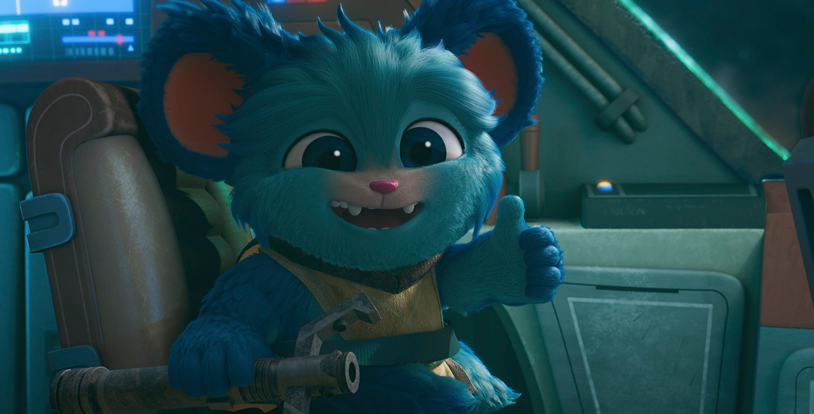 In a scene from the “Star Wars: Young Jedi Adventures,” Nubs (a blue, furry member Poobian species voiced by Dee Bradley Baker), is in a seat inside a blue spacecraft. He is signing a “thumbs up” with his left hand, smiling at the camera. He wears mustard-brown Jedi apparel.