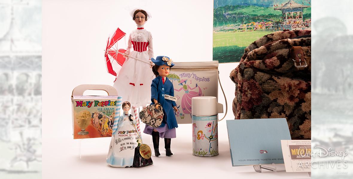 Depicted are various Mary Poppins merchandise items, including two Mary Poppins dolls. One doll is tall and dressed in white, with a red-and-white umbrella, while the other, smaller doll is holding a carpet bag and wearing a blue coat and matching blue hat with flowers. There is also a cardboard ice cream box that reads “Mary Poppins Ice Cream” and features characters from the film riding carousel horses. A ceramic Mary Poppins figurine with two ceramic measuring spoons is featured, along with a lunch bag featuring an illustration of Mary Poppins in a pink-colored dress, with matching thermos featuring the film’s characters riding carousel horses. 