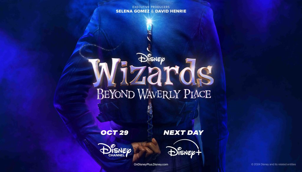 Promotional image for "Wizards Beyond Waverly Place." The image features the back of a character in a dark blue jacket holding a glowing wand behind their back. The title "Wizards Beyond Waverly Place" is prominently displayed in the center, with the release date "Oct 29" and streaming platforms "Disney Channel" and "Disney+" listed below. 