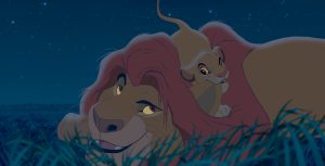 In a scene from Walt Disney Animation Studios' The Lion King, Mufasa relaxes in the grass as his son, Simba, chews on his ear. Stars twinkle in the sky above them.