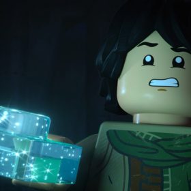 In a scene from LEGO Star Wars: Rebuilding the Galaxy, Sig Greebling (voiced by Gaten Matarazzo) holds a translucent, shimmery, light-blue LEGO piece with his right hand while appearing frightened.