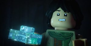 In a scene from LEGO Star Wars: Rebuilding the Galaxy, Sig Greebling (voiced by Gaten Matarazzo) holds a translucent, shimmery, light-blue LEGO piece with his right hand while appearing frightened.