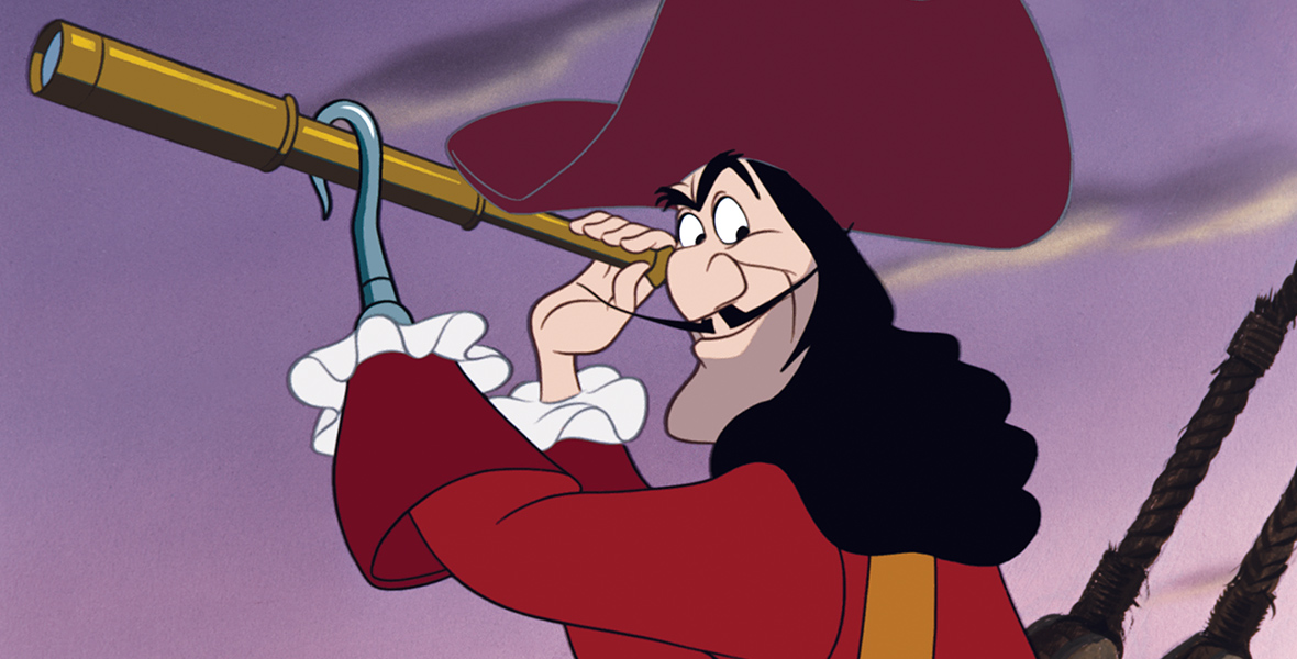 In an image from Peter Pan (1953), Captain Hook (voiced by Hans Conried) holds a telescope in his right hand and his left hook. He looks over his shoulder with a grin. He wears a burgundy hat with a white feather, a gold-trimmed red coat, and a long black wig. The background shows a purple sky and the ropes of a ship.