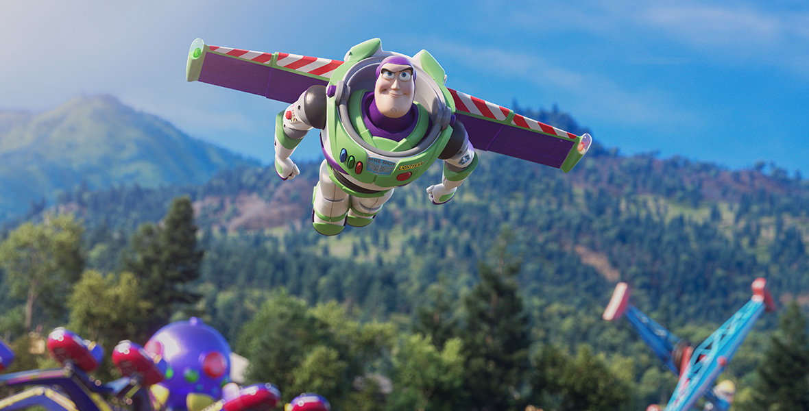 In a scene from Toy Story 4, Buzz Lightyear (voiced by Disney Legend Tim Allen), a spaceman action figure, flies through a bright blue sky. He wears a purple head cap, a clear plastic space helmet, and a green and white suit adorned with a "SPACE RANGER" sticker, purple accents, a yellow nametag, communication buttons, and a jetpack—all reflecting a futuristic space ranger design.