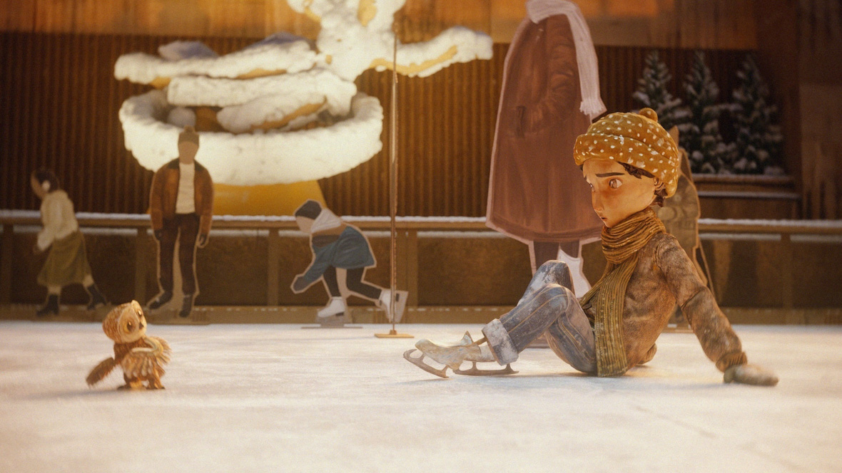 An owl named Moon (left) appears startled after a young girl named Luna falls on the ice while skating in Rockefeller Plaza in a scene from An Almost Christmas Story.