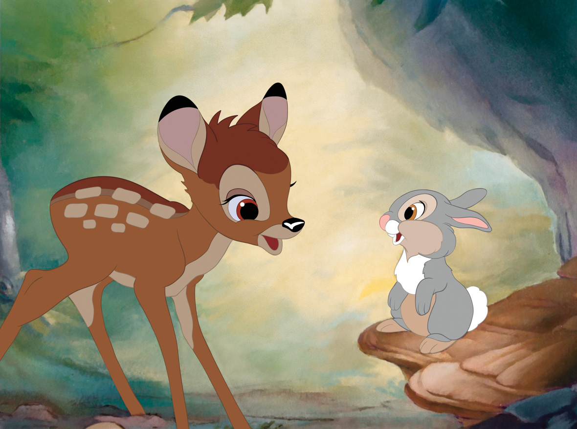 In a scene from Bambi, Bambi (voiced by Donnie Dunagan), a young deer, gazes at Thumper (voiced by Peter Behn), a young rabbit. The two look at each other in amazement. The background showcases watercolor-like designs of a forest, featuring a rock boulder and a leaf.