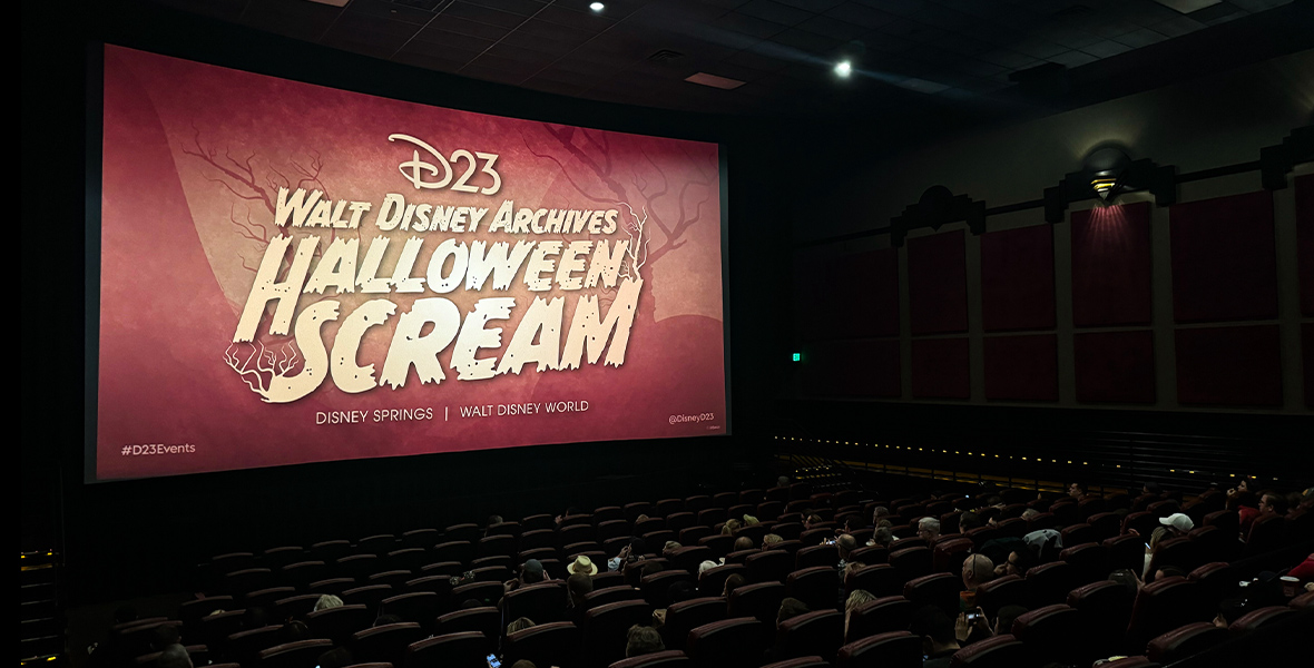 Guests in the Disney Springs AMC Theatre with the “D23 Walt Disney Archives Halloween Scream” logo on the silver screen. Image of yellow, large and bold font that reads “D23 Walt Disney Archives Halloween Scream Disney Springs, Walt Disney World” against a copper background with bare, scary tree silhouettes. There are also branches growing from the “S” and the “M” in the word “scream”