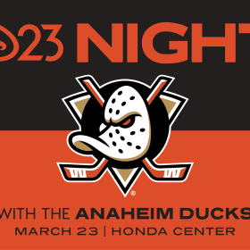 In an image promoting D23 Night with the Anaheim Ducks, the upper half of the image contains large orange text—on a black background—which reads “D23 Night”; the lower half of the image contains black text—on an orange background—which reads “With the Anaheim Ducks, March 23, Honda Center.” The Anaheim Ducks logo, a duck-shaped hockey mask against two orange hockey sticks, is seen at center.