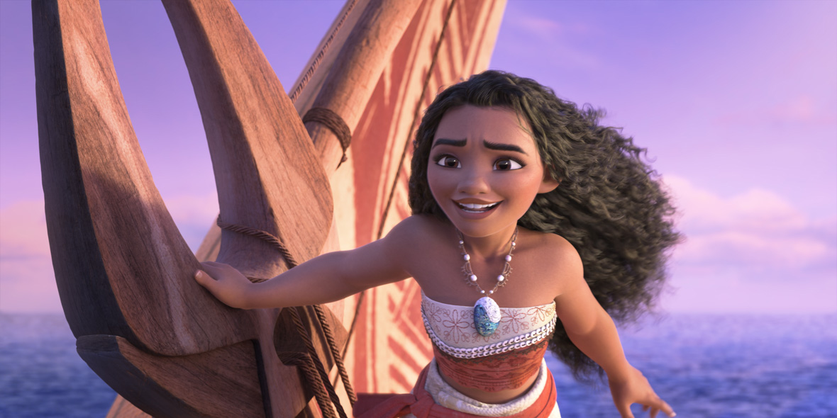 In an image from Walt Disney Animation Studios’ Moana 2, Moana (voiced by Auli‘i Cravalho) is sailing on her canoe in the middle of the ocean. She’s steering the canoe with one hand, and her hair is windswept. She has a hopeful expression on her face. 