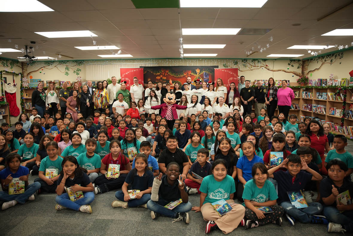 In an image from the Mickey Around the World Toy Drive Tour, Mickey Mouse poses with students, Disney VoluntEARS, and teachers at Endeavour Elementary School.