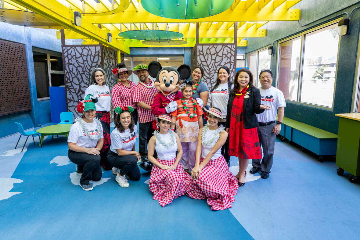 In an image from the Mickey Around the World Toy Drive Tour, Mickey Mouse poses with children and their families at Kapi‘olani Medical Center for Women & Children.