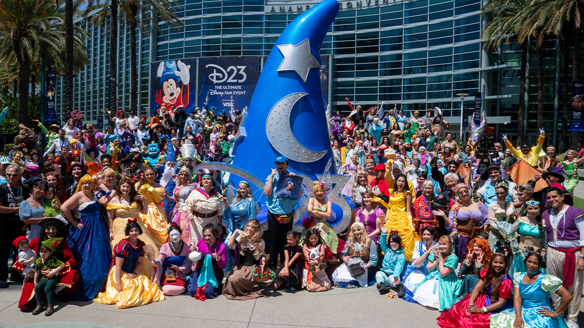 Cosplayers gathered around a Sorcerer's Hat statue at D23: The Ultimate Disney Fan Event.