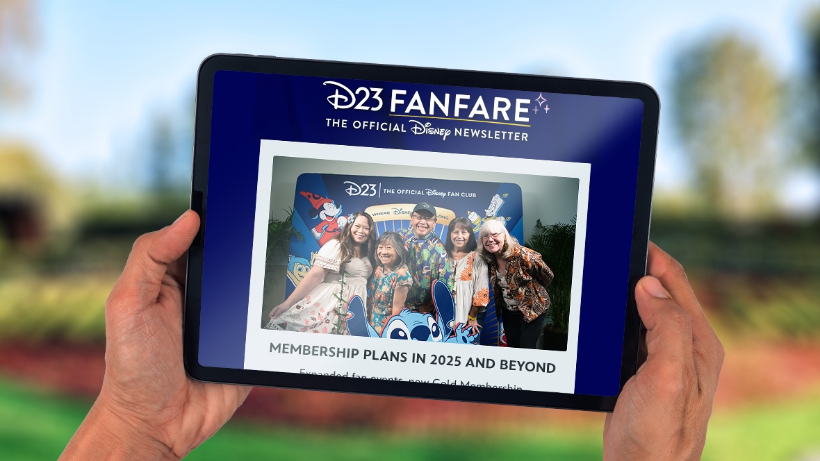 Hands holding a tablet that has D23 FanFare pulled up, getting information on new Membership Plans.