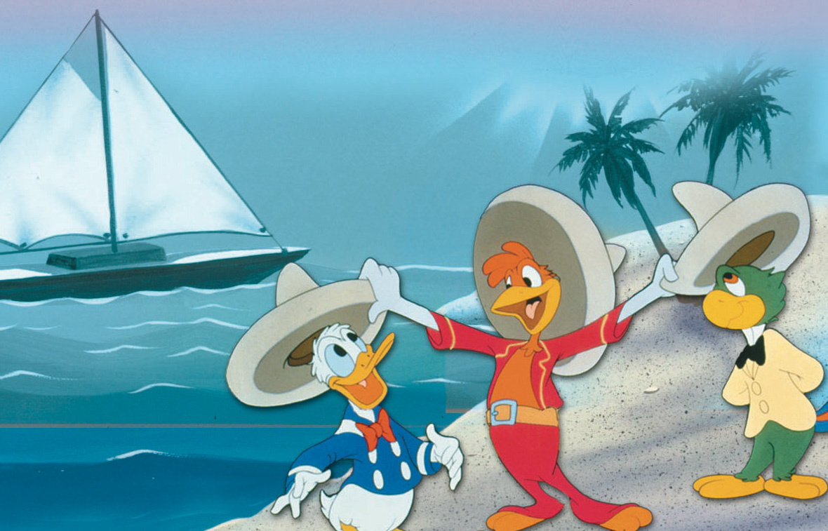 An image of The Three Caballeros—Donald Duck, José Carioca, and Panchito—standing on a beach, with a boat in the background.