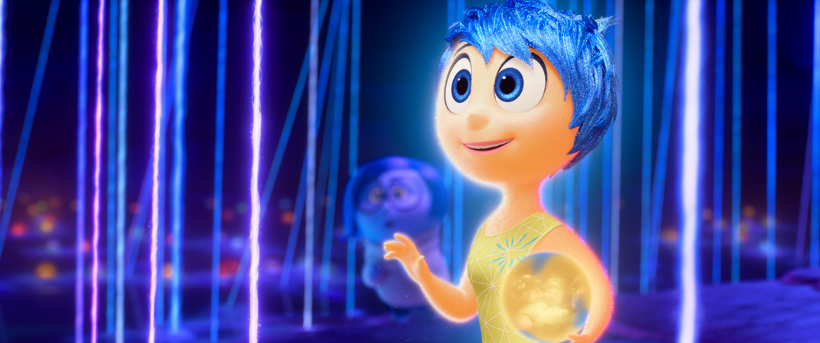 In an image from Inside Out 2, Joy (voiced by Amy Poehler) is looking off-camera at something to the left while holding a memory ball.