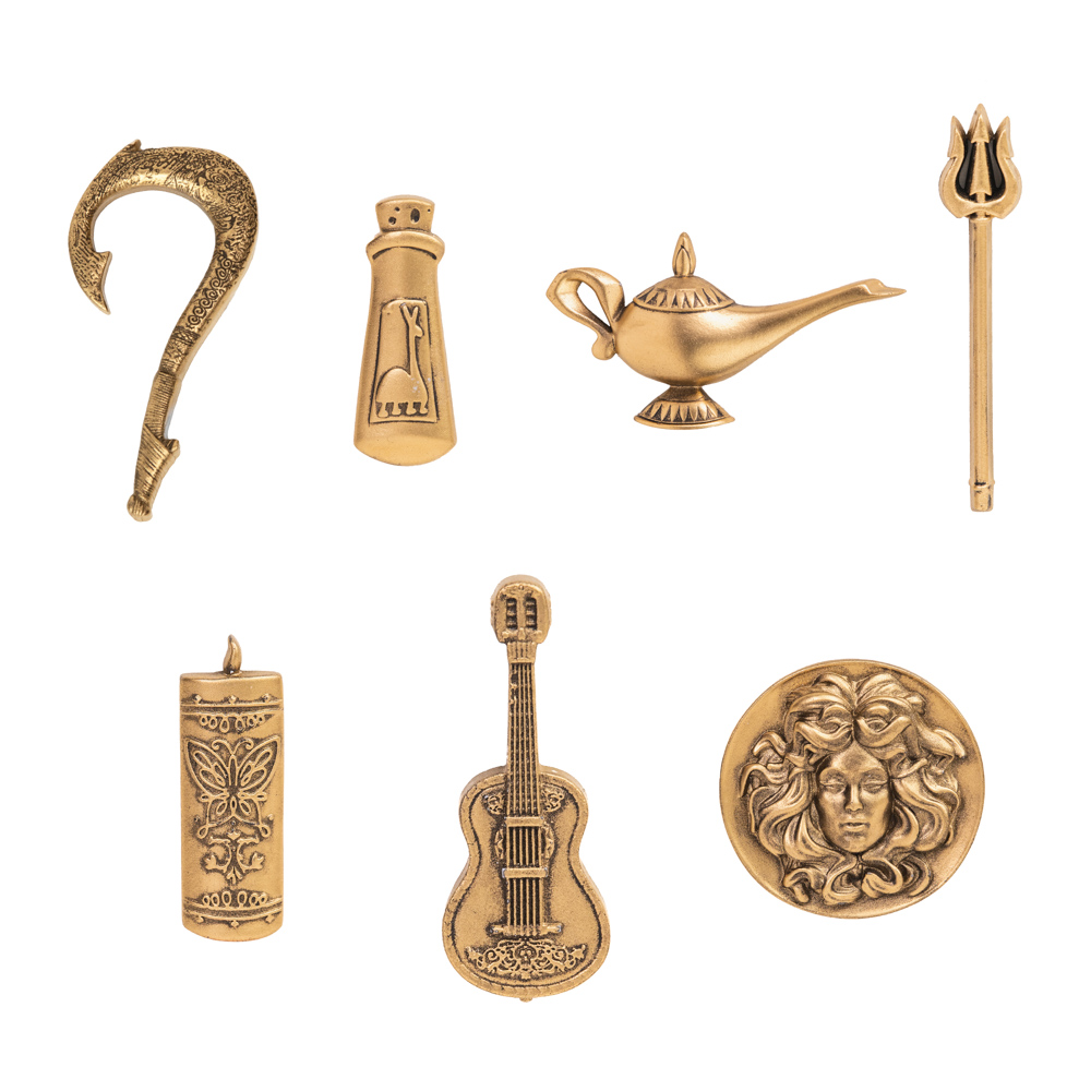 The seven gold enchanted objects pins from the Enchanted Objects Mystery Pin Blind Pack, part of D23’s 2024 Gold Member Collector Set, are shown— (left to right): on the top, Maui’s Fishhook, Yzma’s Llama Potion, Genie’s Magic Lamp, and King Triton's Trident; on the bottom, The Family Madrigal Candle, Miguel’s Guitar, and Madame Leota’s Crystal Ball.