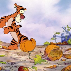 In an image from the animated film Winnie the Pooh and Tigger Too, Tigger stands in a ruined vegetable garden. He has a worried look on his face as he looks down at his feet, one of which is stuck in a broken clay pot. Around him on the ground are broken carrots and pumpkins and two sticks that have paper labels attached at the top, one for carrots and one for pumpkins, both of which are misspelled.