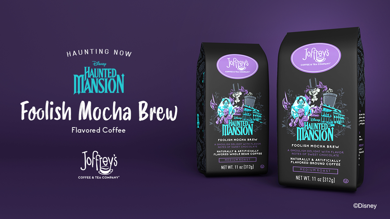 Two specialty coffee bags sit in front of a dark purple background. The coffee bags house and advertise the FOOLISH MOCHA BREW. The description reads: A GHOULISH DELIGHT WITH FLAVOR NOTES OF SWEET CHOCOLATE. NATURALLY ARTIFICIALLY FLAVORED GROUND COFFEE. MEDIUM ROAST. NET WT. 11 oz [312g]. To the left of the bags is a headline and description reading: HAUNTING NOW. DISNEY HAUNTED MANSION (logo). FOOLISH MOCHA BREW. Flavored Coffee. Joffrey’s Coffee & Tea Company (logo). A ©Disney disclaimer is positioned at the bottom right corner.