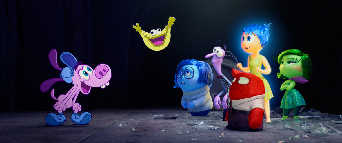 In a scene from Disney and Pixar's Inside Out 2, Bloofy, a purple 2D cartoon canine TV host, and Pouchy, a yellow fanny pack with googly eyes, face Riley's core Emotions: Sadness, Fear, Anger, Joy, and Disgust.