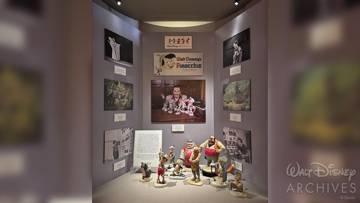 A display case at Carthay Circle Restaurant & Lounge at Disney California Adventure Park features the same nine animator’s models from the recent photo shoot arranged at the base. A series of historical photographs from the development of Pinocchio are arranged along the sides of the case. 