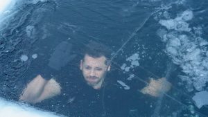 David Blaine pounds against a frozen-over hole in the ice.