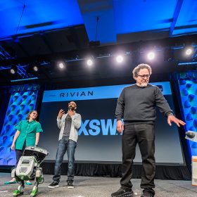 Panel discussion at SXSW for Disney featuring Jon Favreau and other speakers on stage with a Star Wars robot.