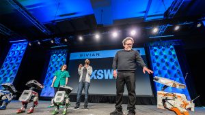 Panel discussion at SXSW for Disney featuring Jon Favreau and other speakers on stage with a Star Wars robot.