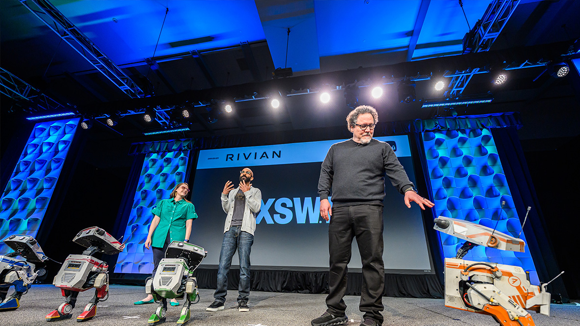 Panel discussion at SXSW for Disney featuring Jon Favreau and other speakers on stage with a Star Wars robot.