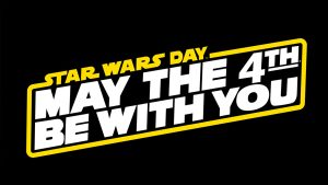 White and yellow logo reading “Star Wars Day, May the 4th Be With You” on a black background.