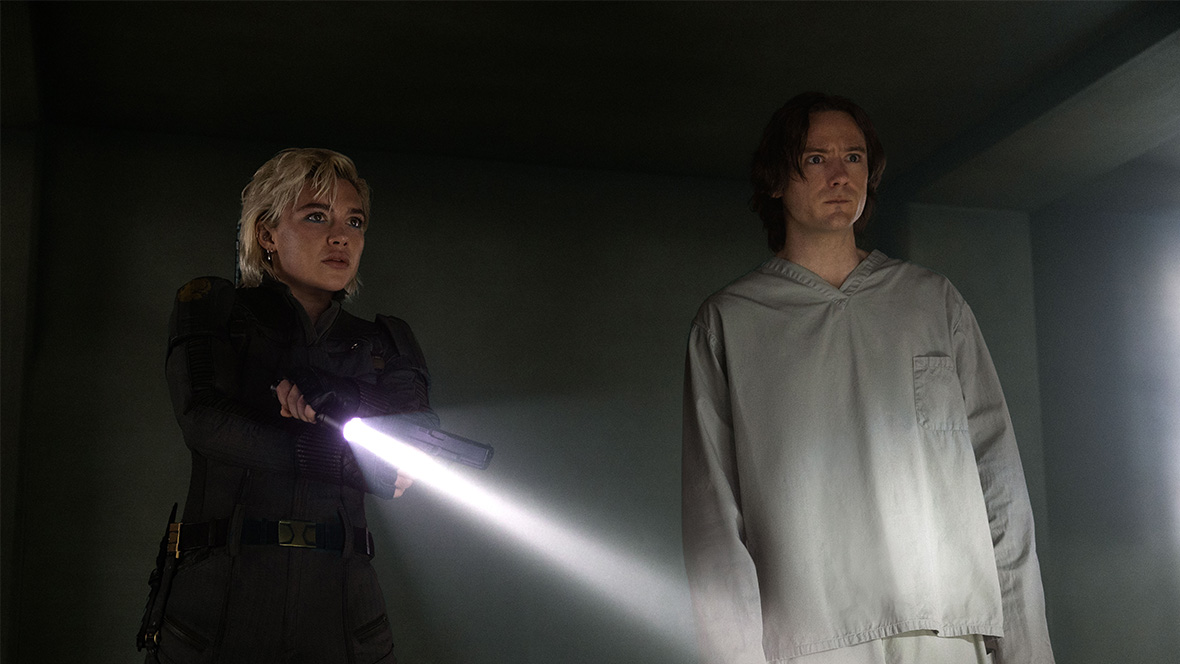 Yelena Belova (Florence Pugh) uses a flashlight as she tries to escape the vault with Bob (Lewis Pullman) in Marvel Studios' Thunderbolts*.