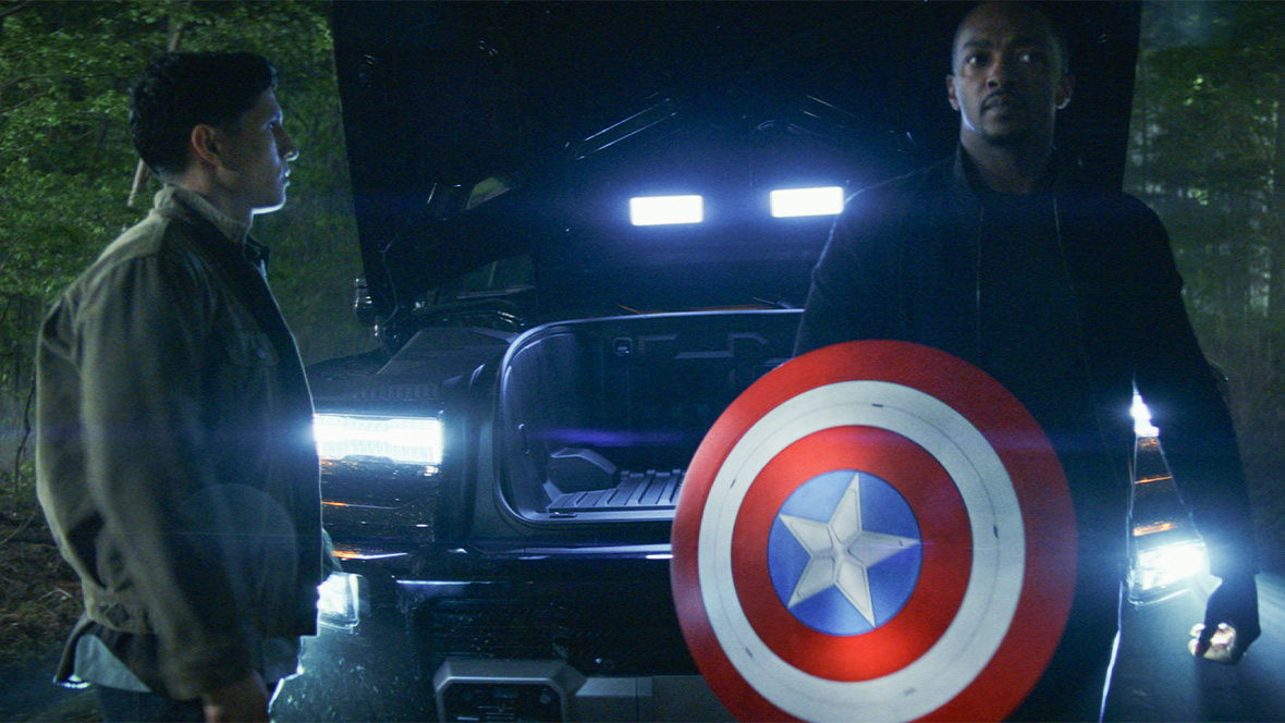 Joaquin Torres (Danny Ramirez) looks at Sam Wilson (Anthony Mackie), who is holding Captain America’s shield, in Marvel Studios’ Captain America: Brave New World.