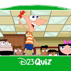 In a photo from season 5 of Phineas and Ferb, Phineas is standing on a desk and pointing, surrounded by Ferb, Isabella, Baljeet, Buford, and other students in a classroom.