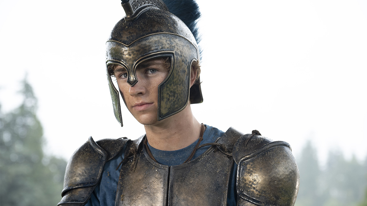 Percy from Percy Jackson and the Olympians wearing an ancient helmet and armor over a blue long-sleeved shirt.