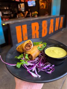 The Crispy Birria Roll from URBANA Mexican Gastronomy. Includes Oaxacan Cheese, Chef Ernie's Salsa Verde, and pictured with a side of slaw.