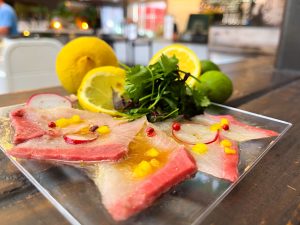 The “Finding Carpaccio” dish from Zabon Ramen and Rolls. Pictured are thinly sliced Yellow Tail,  in Chef's yuzu ponzu sauce, topped with greens.
