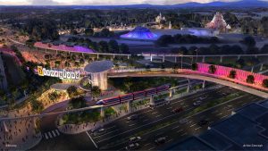 Artist rendering of a new transportation hub coming to Disneyland Resort. The hub features a red monorail and pedestrian bridge, lit up in pink lights. A pedestrian bridge is seen over a street, passing behind a sign for Disneyland Resort. In the background, attractions such as Space Mountain, Matterhorn, and Sleeping Beauty’s Castle can be seen.