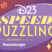 A promotional image for D23’s Speed Puzzling event presented by Ravensburger. The main text is set on a purple disc and in stylized yellow text— “speed” is bold and italicized. D23 and Ravensburger appear in white text. The main background of the image is an array of soft oranges and purples, with outlines of puzzle pieces and geometric shapes. Several orange puzzles appear around the text.