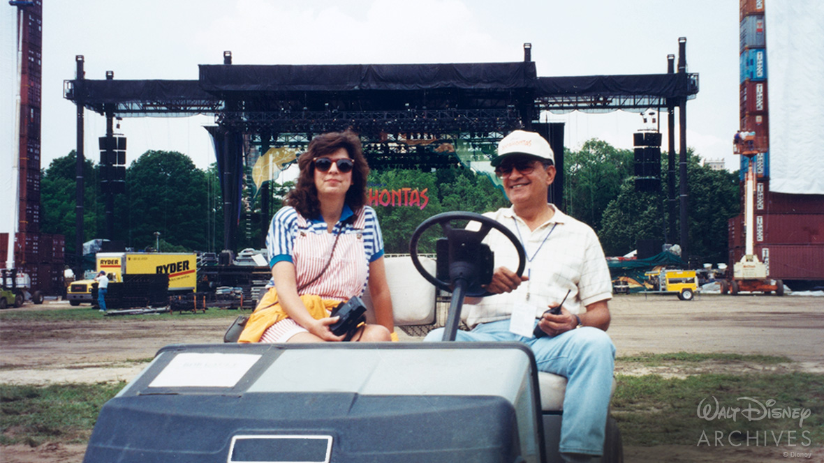 Future Disney Legend James “Jim” Cora sits to the right of his daughter, René Cora-Wong, in a golf cart during the construction of the main stage for the premiere of Pocahontas.