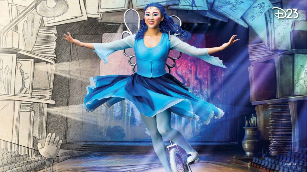 A promotional image for Drawn to Life presented by Cirque du Soleil and Disney at Disney Springs in Orlando, Florida. The left side of the image features a hand-drawn theater, with rows of seats sketched by pencil with monochrome shading. The right side of the image transitions from the hand-drawn style into a full color photo of a theater stage. The stage is framed by large pages from a sketchbook, and as the image moves from left to right, the sketches move from a hand-drawn style to being in color. In the foreground of the image is a Drawn to Life performer and character, representing the Blue Fairy from Pinocchio during a unicycle act. The female-presenting character is in a flowy dress in shades of blue and wearing a dark blue wig and silver wings. While on the unicycle, the character evokes action and grace. The D23 logo is in the bottom right corner in white.