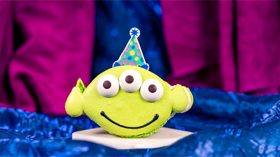 Macaroon shaped and decorated like the Little Green Men from the Toy Story films and topped with a chocolate party hat, available at Alien Pizza Planet at Disneyland Park.